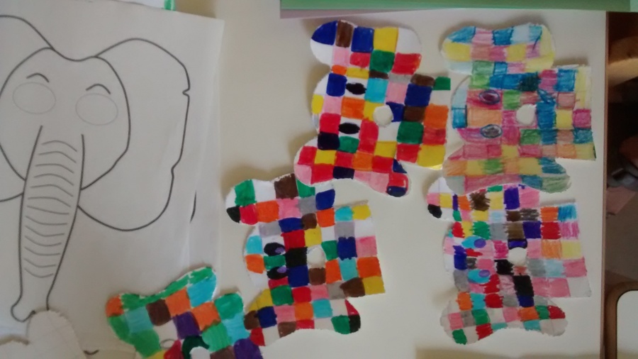 Elefanti a patchwork colorati realizzati dai bambini in classe, accanto al disegno di un elefante da colorare