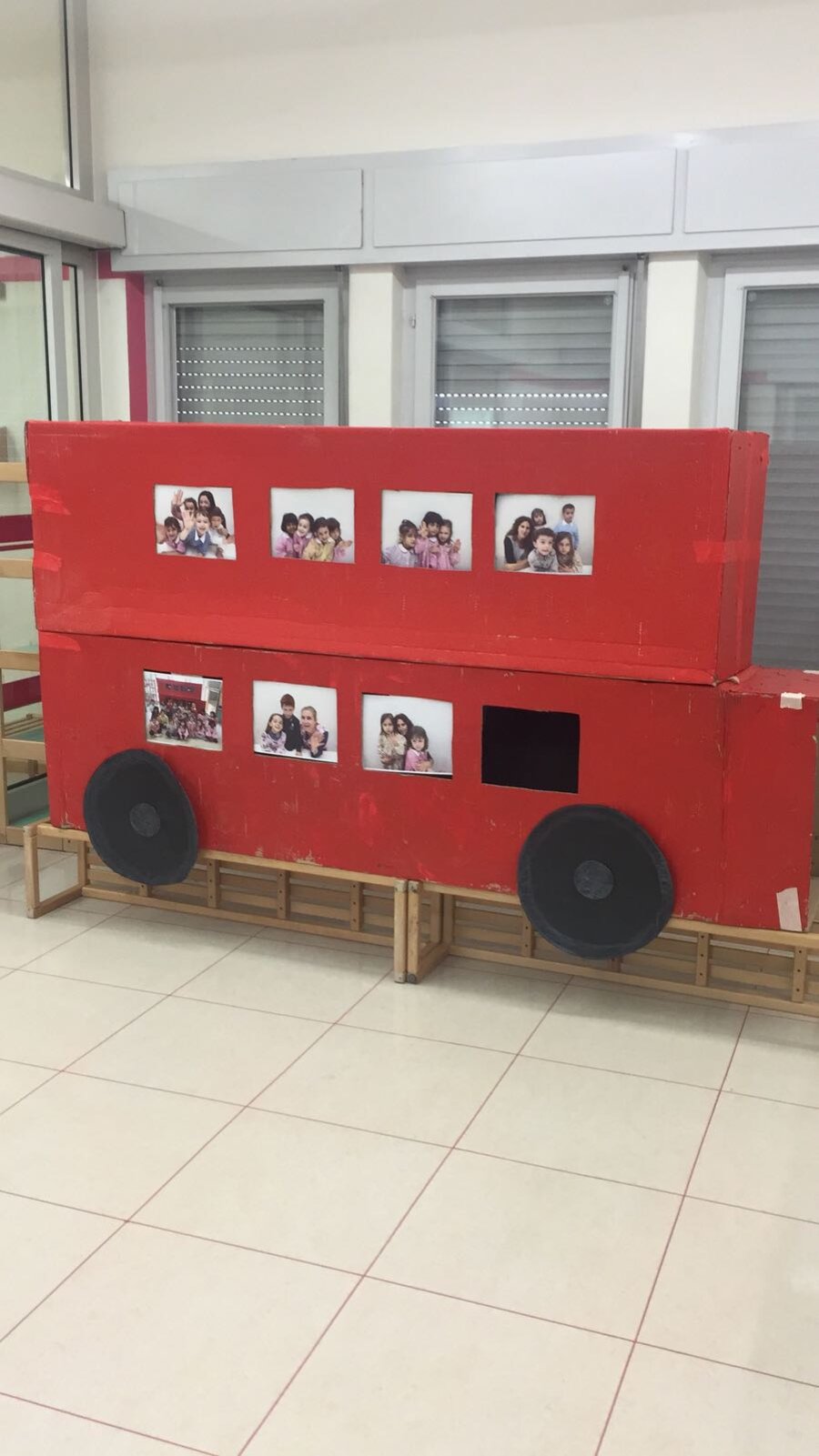 Autobus londinese a due piani costruito a mano con le foto dei bambini alle finestre