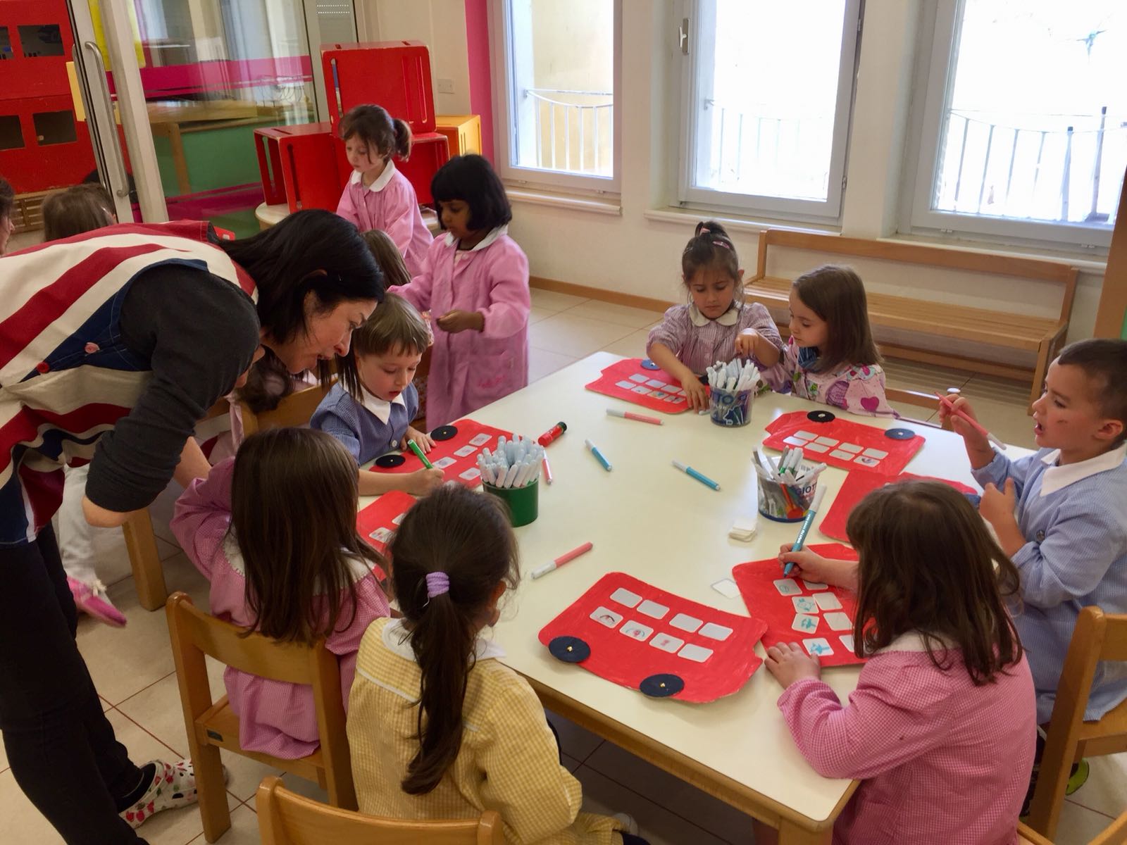 Luisa e un gruppo di bambini al lavoro su un'attività a tema Londra e Paddington Bear